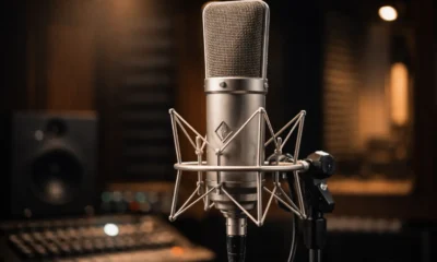 Neumann U 87 Ai condenser microphone mounted in a professional recording studio with warm cinematic lighting